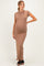 woman wearing a tan pregnant bodycon maxi dress showing her baby bump and paired with black heels