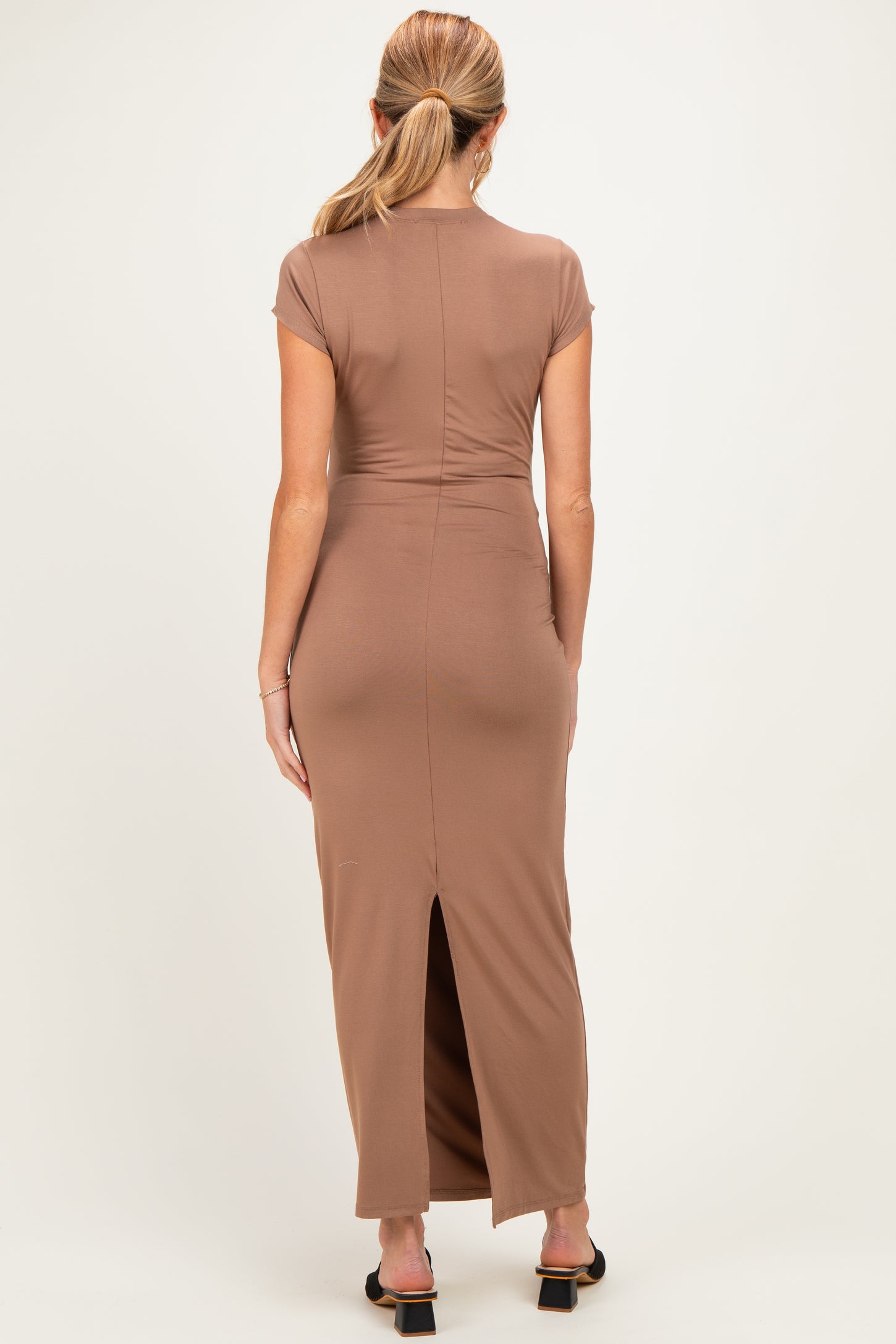 woman wearing a brown maternity maxi dress with a back slit and cap sleeves