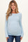 woman wearing a light blue long sleeve maternity top with ruching, highlighting her baby bump