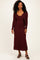 woman wearing a burgundy ribbed maxi dress with a matching cardigan and black heeled sandals
