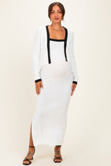 woman wearing a white maternity maxi dress with a black trim cardigan and showing her baby bump