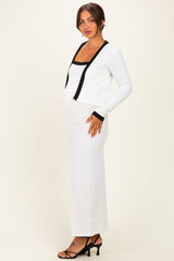 woman wearing a white ribbed maternity dress with black accents, showcasing her baby bump