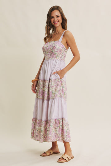 woman wearing a lavender floral maxi dress with a tiered design and pockets
