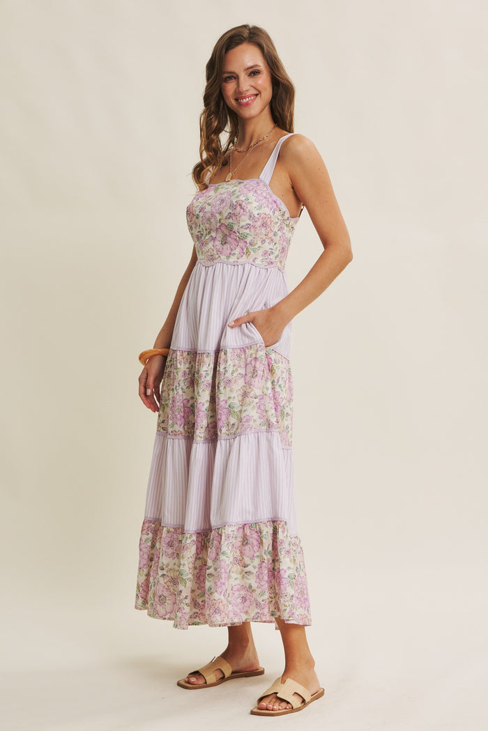 woman wearing a lavender floral maxi dress with a tiered design and pockets
