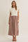 woman wearing a cream cap sleeve top with a plaid maxi skirt in earthy tones