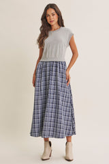 woman wearing a gray cap sleeve top with a blue plaid maxi skirt and beige ankle boots
