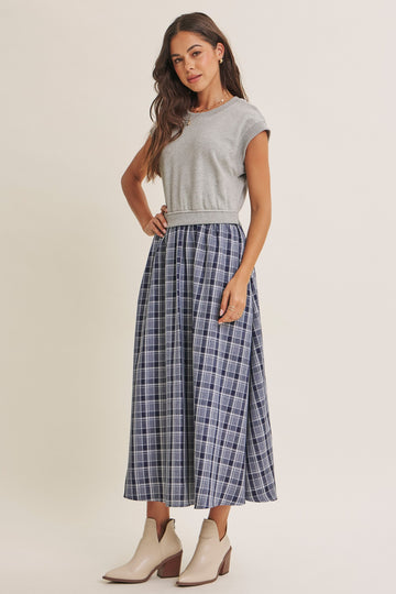 woman wearing a gray short sleeve top and a navy plaid maxi skirt with beige ankle boots