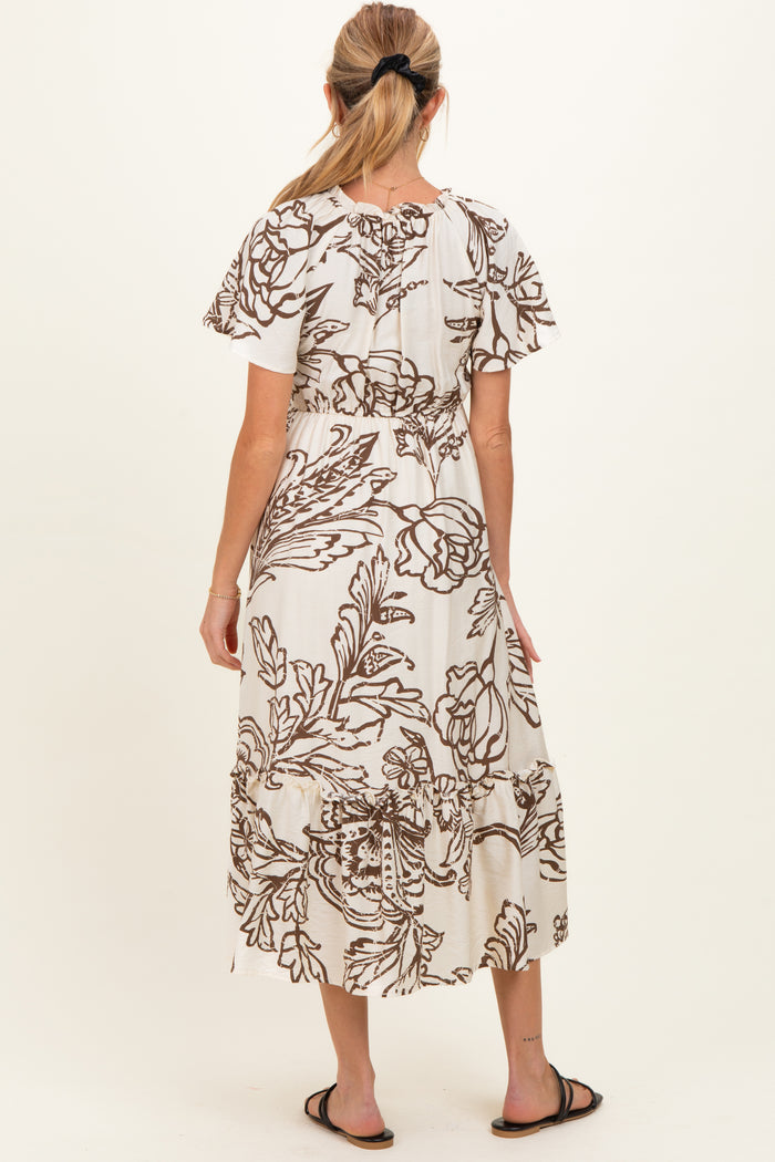 woman wearing a floral print maternity maxi dress with short flutter sleeves and a flowing skirt, seen from the back