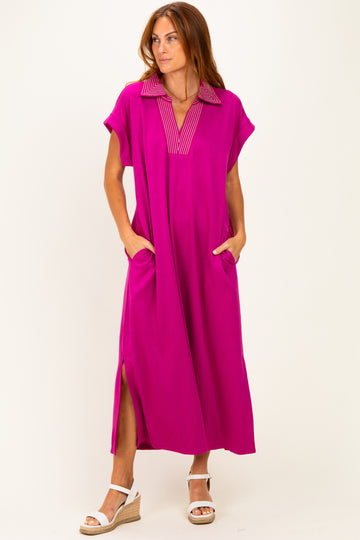 woman wearing a bright pink maxi dress with a collar and side pockets, standing against a white background