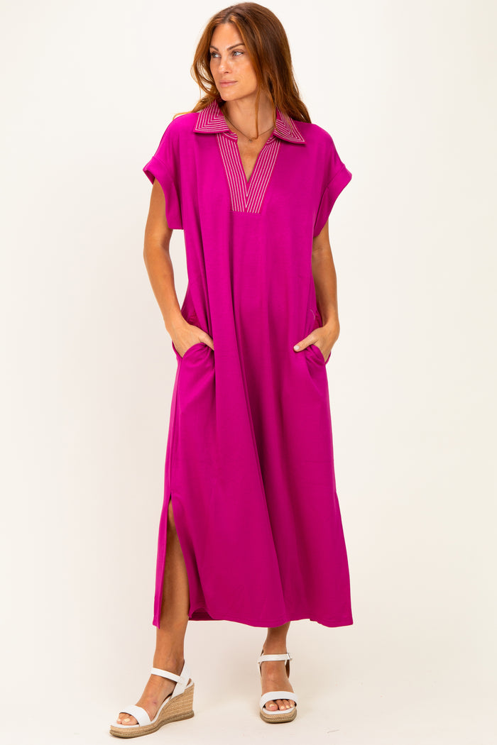 woman wearing a bright pink maxi dress with a collar and side pockets, standing against a white background