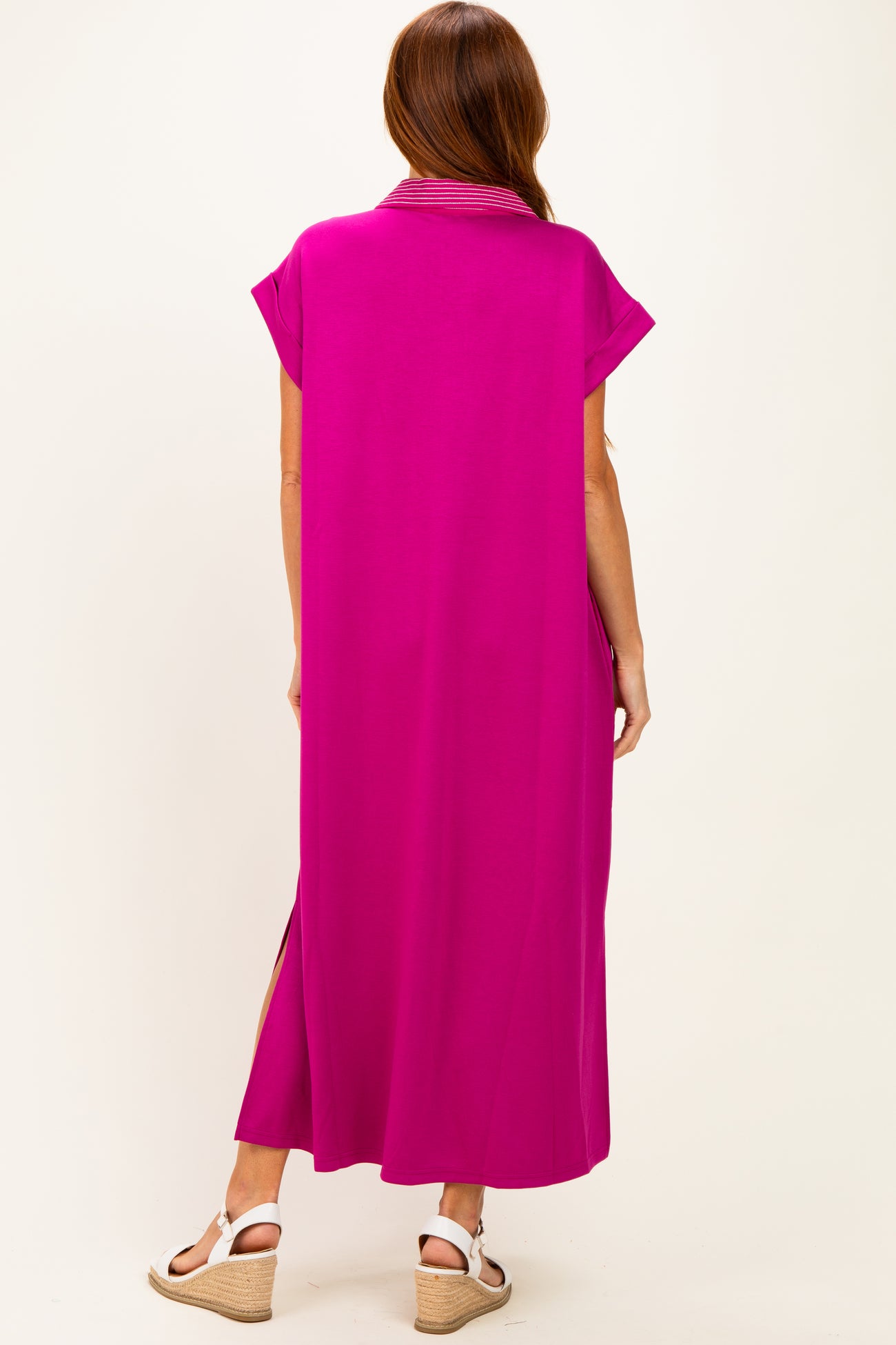 woman wearing a vibrant fuchsia maxi dress with short sleeves and side slits