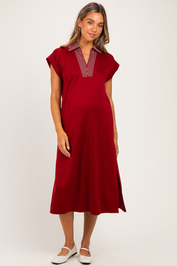 woman wearing a red maternity dress with a striped collar and side slits, showing her baby bump