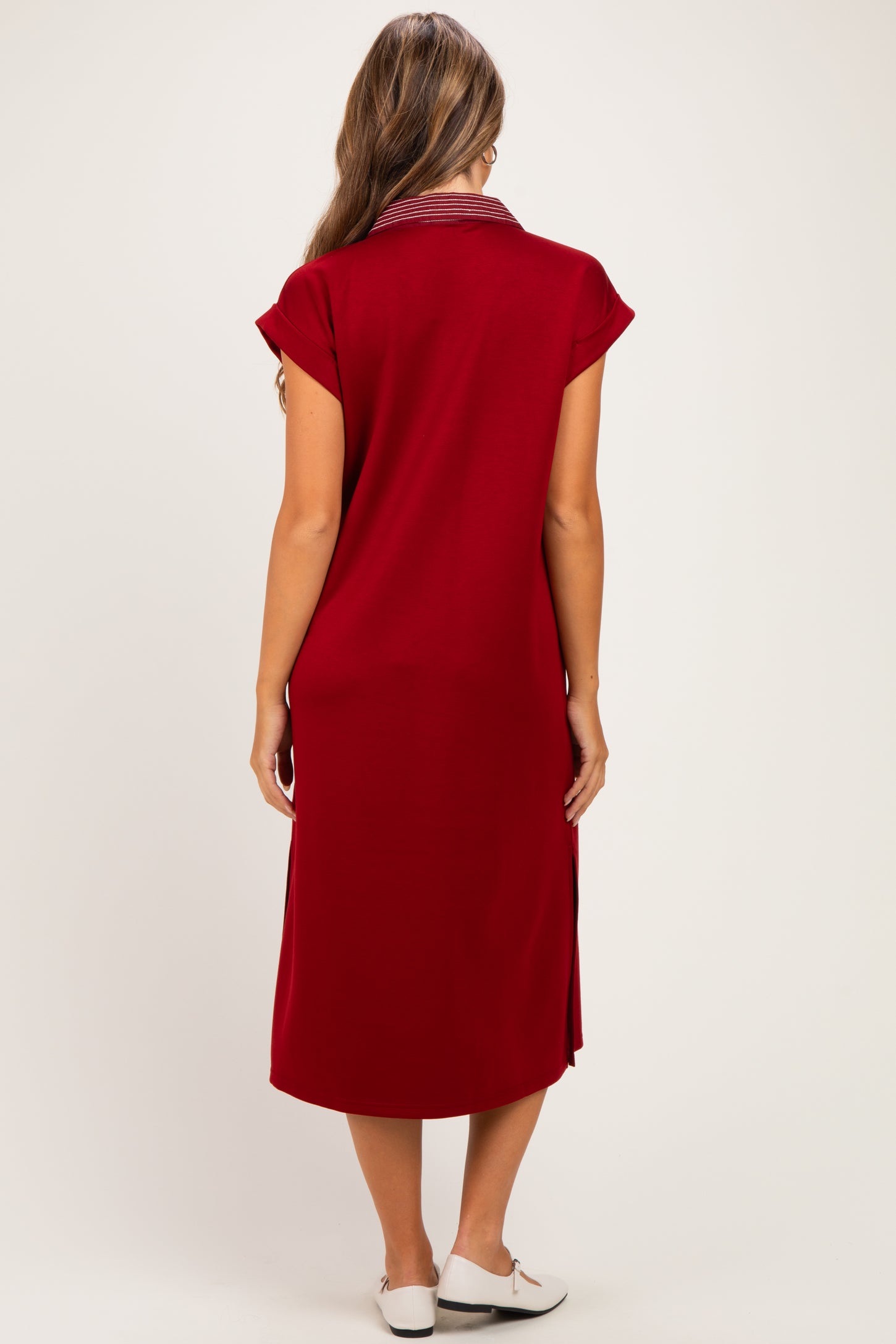 woman wearing a red maternity dress with a collar and short sleeves, showing the back view