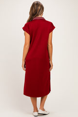 woman wearing a red maternity dress with a collar and short sleeves, showing the back view