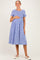 woman wearing a blue and white gingham maternity dress with short sleeves and a baby bump
