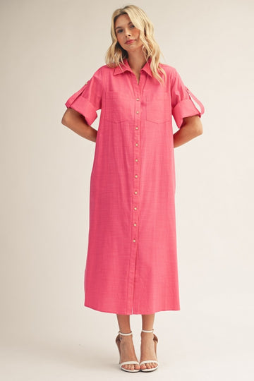 woman wearing a bright pink midi shirt dress with button-down front and rolled short sleeves