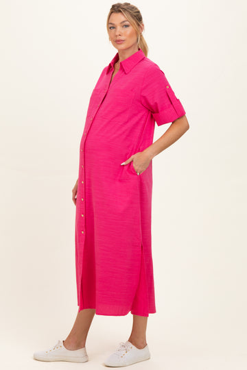 woman wearing a bright pink short sleeve maternity dress with buttons and pockets, showcasing her baby bump