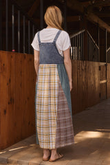 woman wearing a denim smock dress over a white t-shirt, featuring a patchwork design with plaid patterns