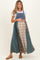 woman wearing a denim maternity maxi dress with mixed plaid patterns and holding her baby bump