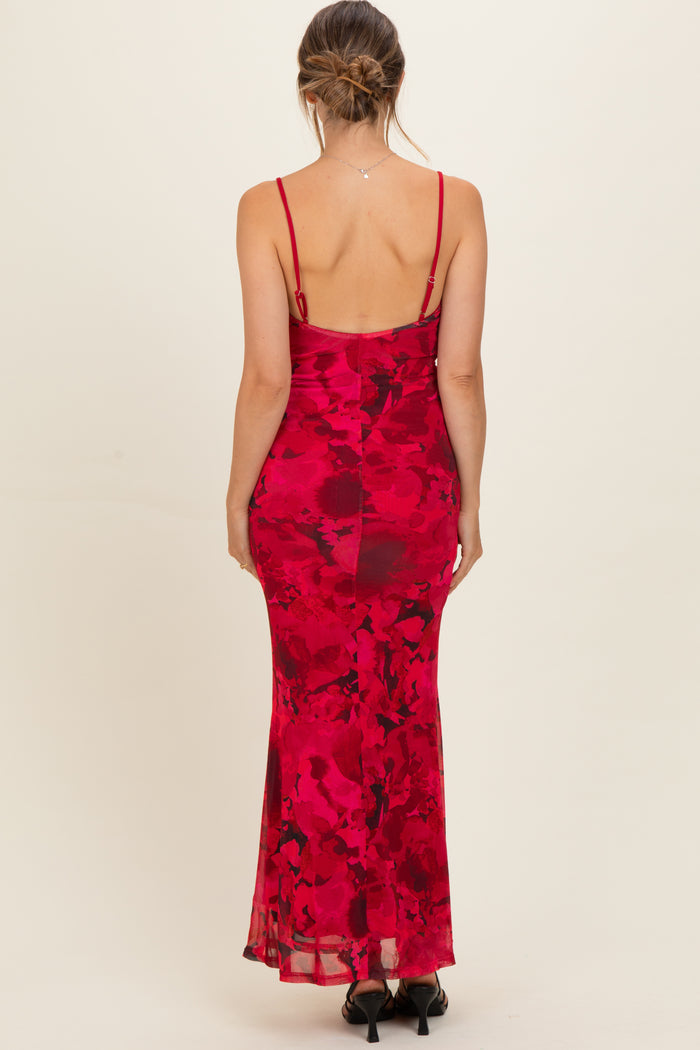 woman wearing a red floral maternity dress with a fitted silhouette and spaghetti straps
