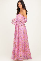 woman wearing a pink floral off-the-shoulder maxi dress with long puff sleeves