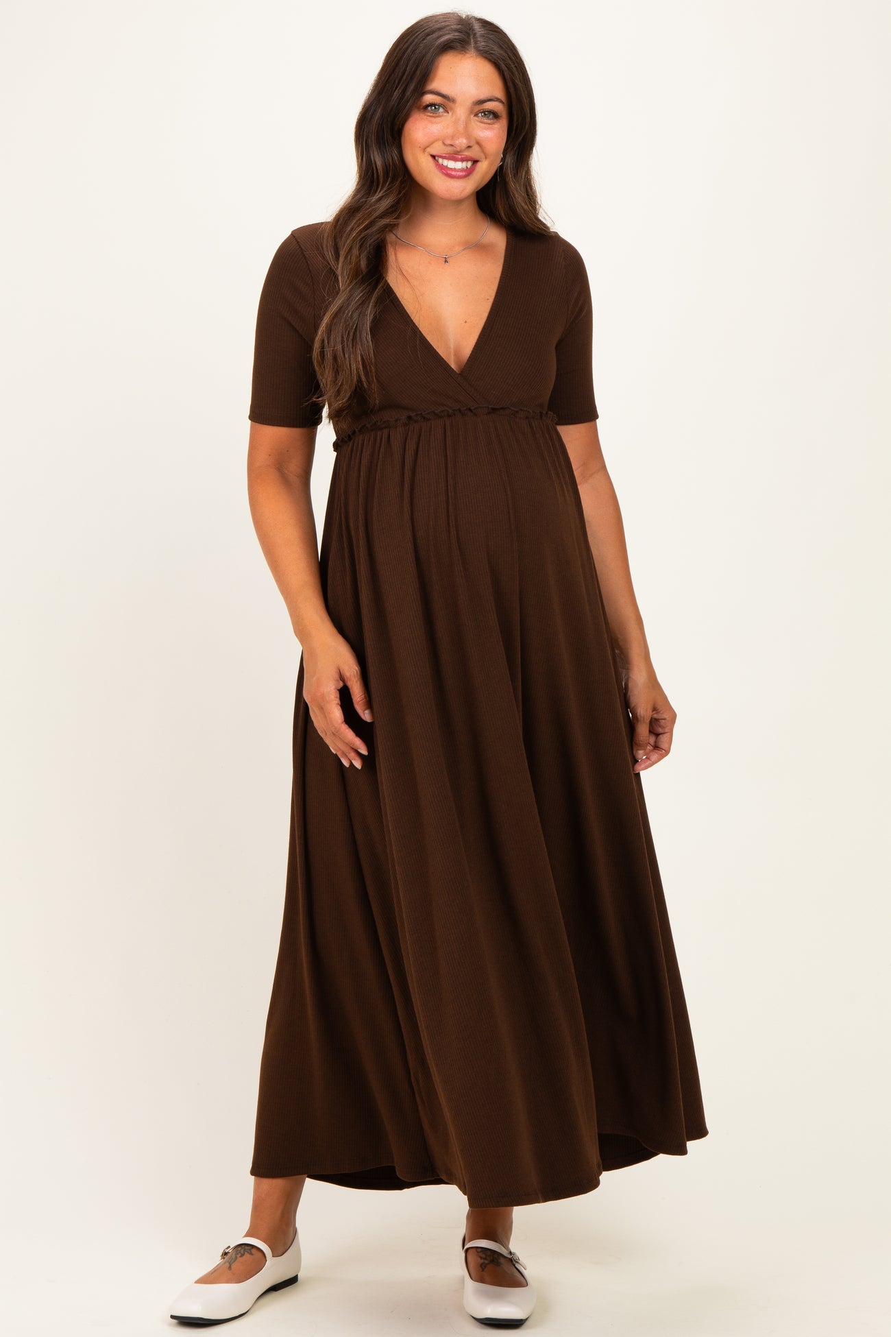 woman wearing a brown short sleeve maternity maxi dress with a v-neck and a cinched waist, showcasing her baby bump
