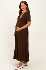 woman wearing a brown short sleeve maternity dress with a deep v-neck and a baby bump visible