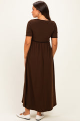 woman wearing a brown maternity maxi dress with short sleeves and a cinched waist, showing the back view