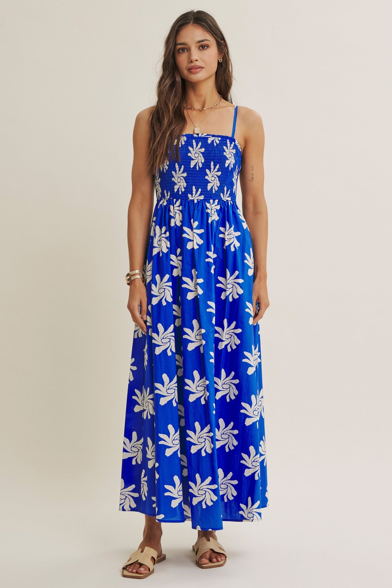 woman wearing a blue floral maxi dress with spaghetti straps and a smocked bodice