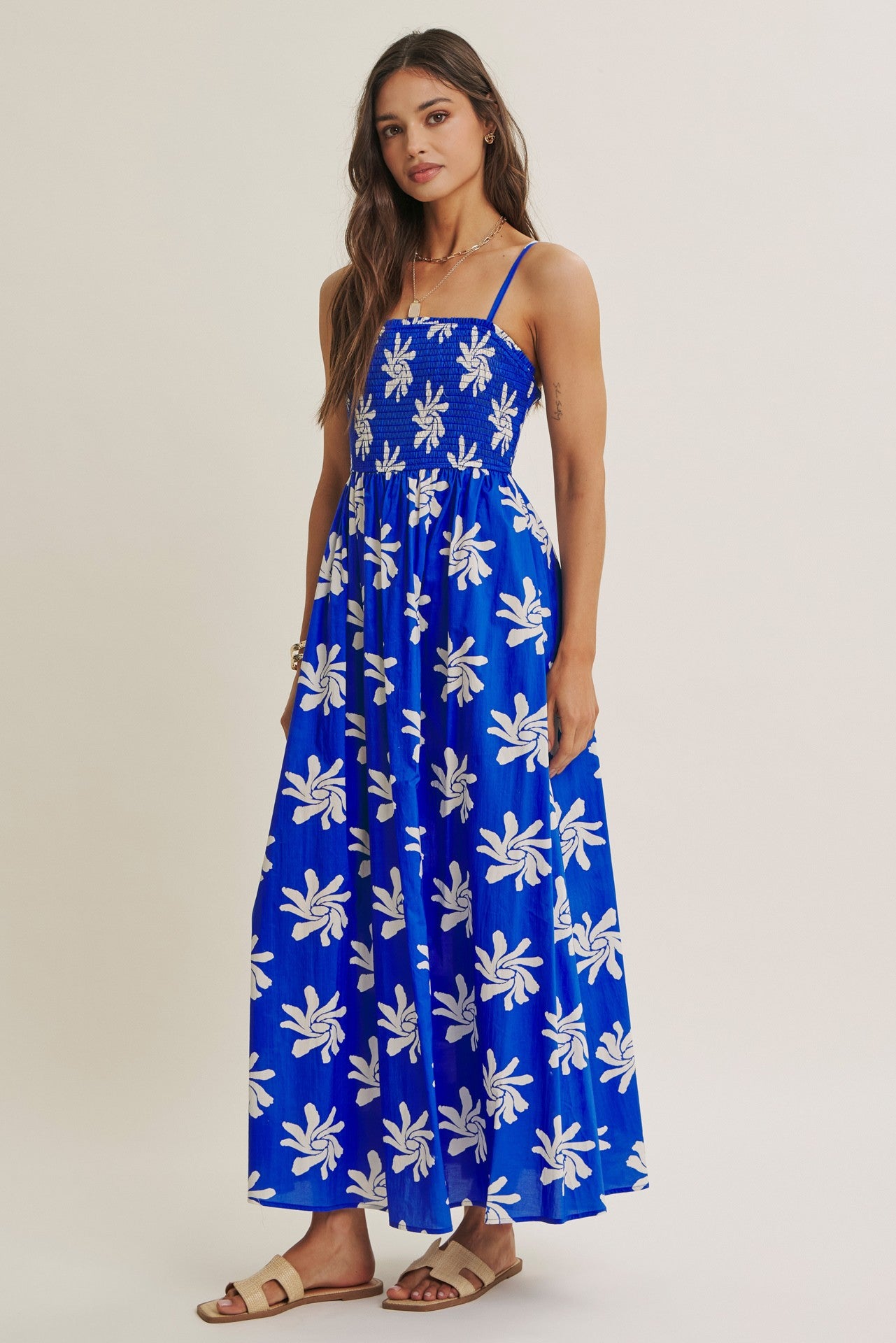 woman wearing a blue floral maxi dress with spaghetti straps and a smocked bodice