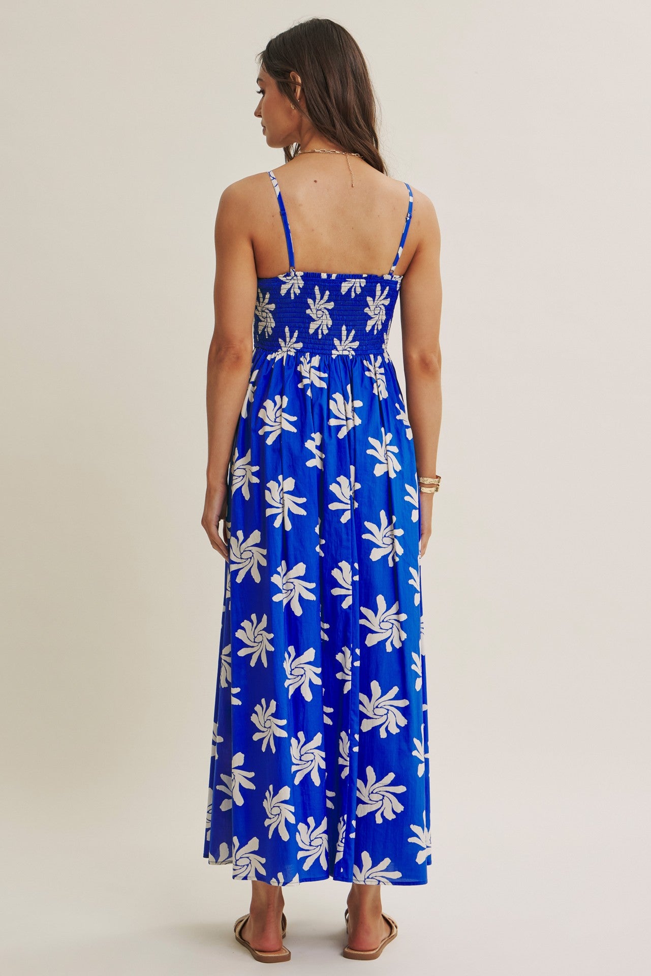 woman wearing a blue floral maxi dress with thin straps and a smocked back