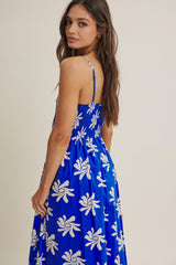 woman wearing a blue floral maxi dress with spaghetti straps, showing the back view and flowy skirt