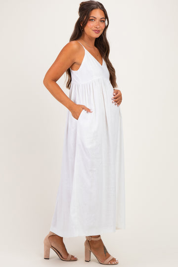 woman wearing a white maternity maxi dress with pockets and a baby bump visible