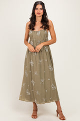woman wearing a khaki floral strapless maxi dress with a flowy skirt and a fitted bodice