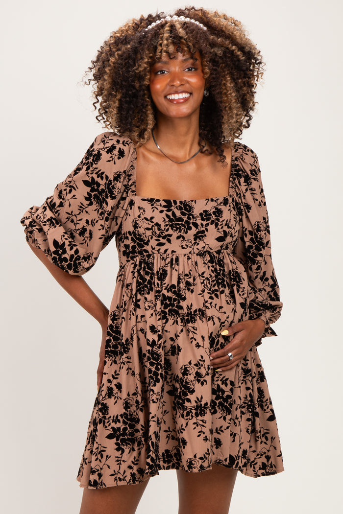 woman wearing a brown floral maternity dress with puff sleeves and a visible baby bump