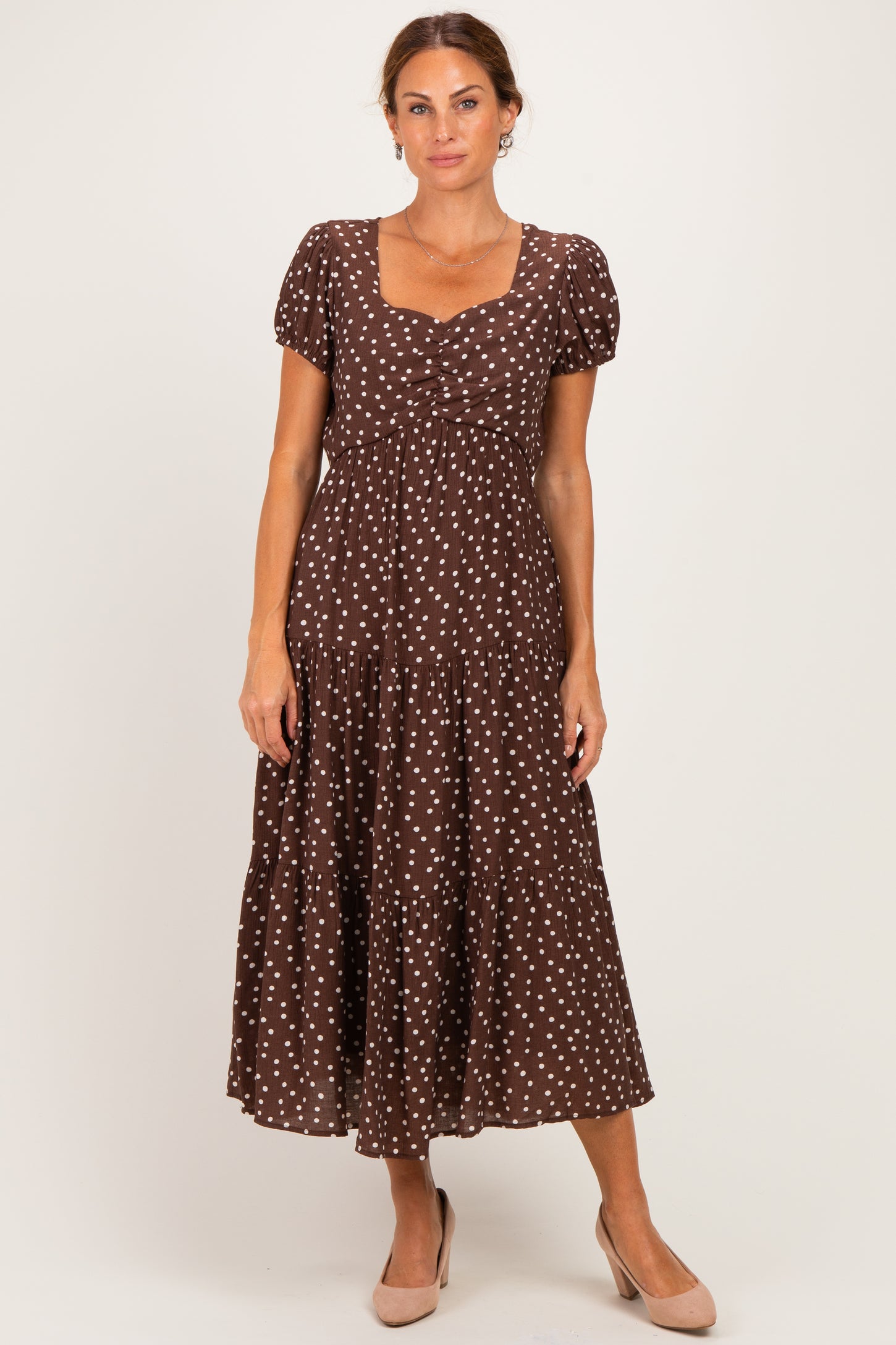 woman wearing a brown polka dot midi dress with short sleeves and a square neckline