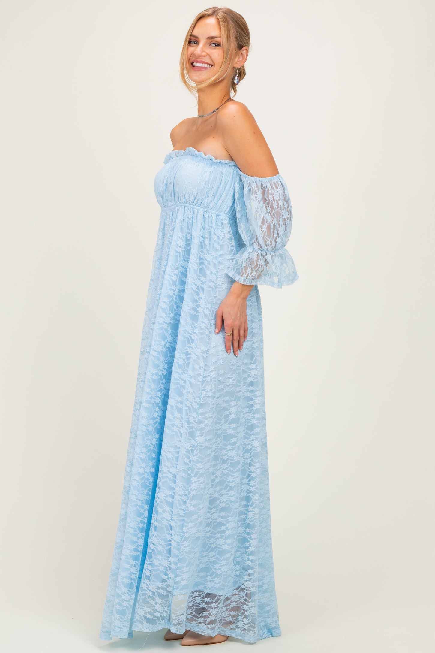 woman wearing a light blue off-the-shoulder maxi dress with lace details and long puff sleeves