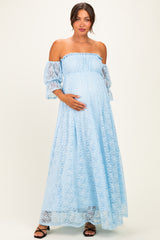 woman wearing a light blue off-shoulder maternity dress with ruffled sleeves and a visible baby bump