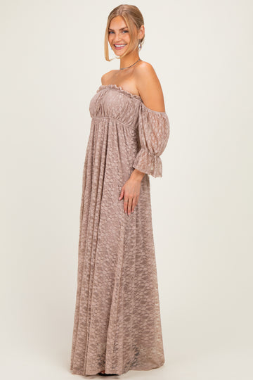 woman wearing a taupe off-the-shoulder maxi dress with sheer sleeves and a flowing silhouette