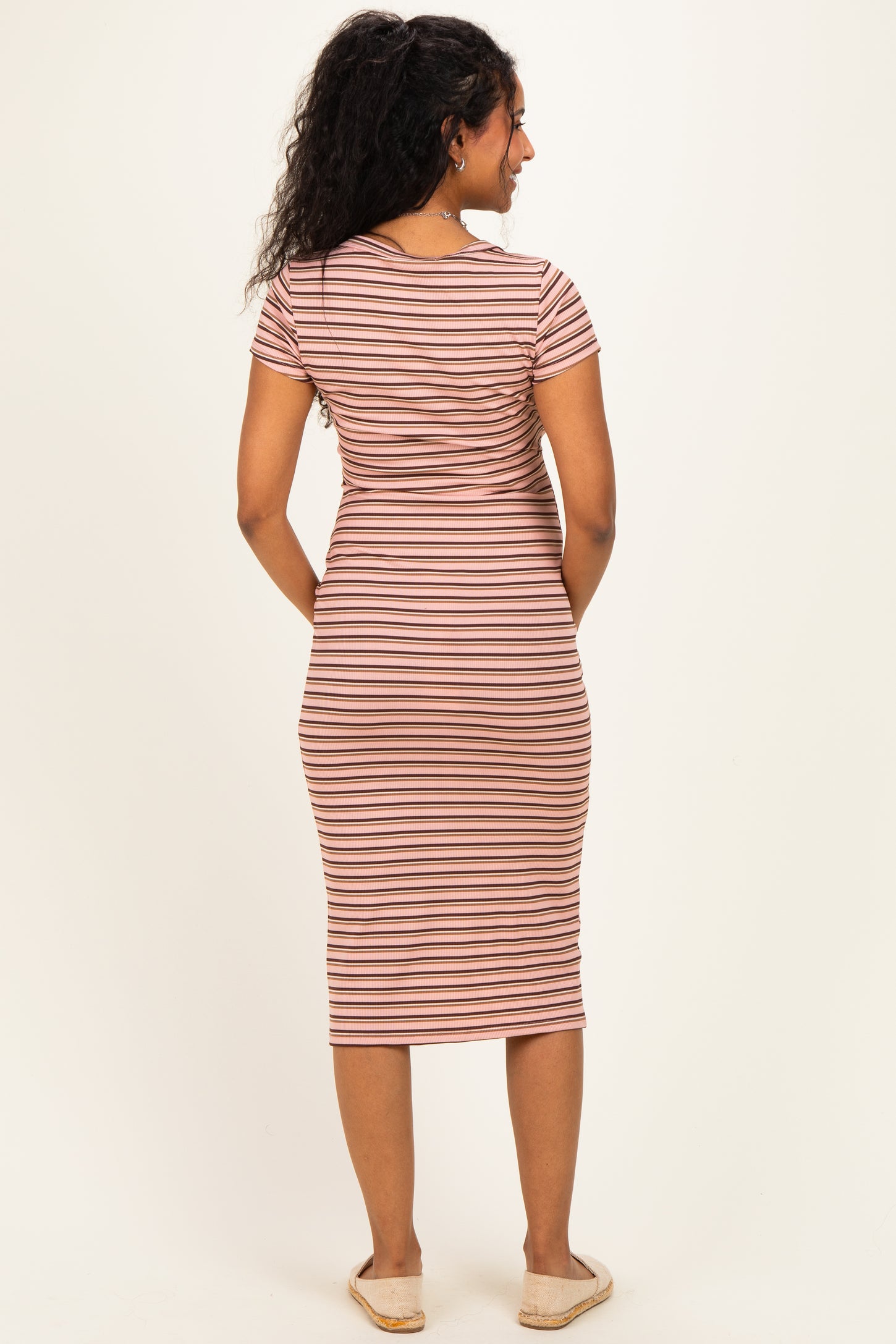 woman wearing a striped maternity midi dress with short sleeves and a fitted silhouette, showcasing her baby bump from the back