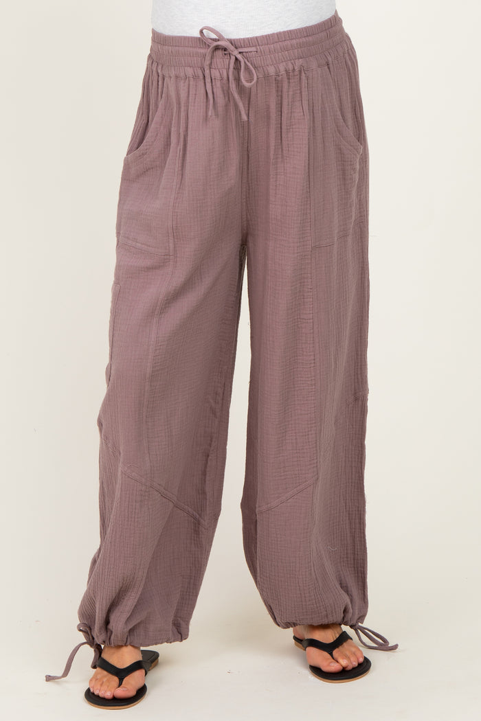 woman wearing mauve maternity pants with pockets and elastic drawstring waist, paired with black sandals