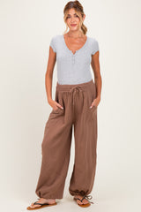woman wearing a grey short sleeve henley top and brown maternity pants with drawstring and elastic cuffs