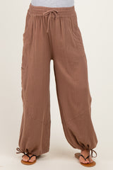woman wearing brown maternity pants with a relaxed fit and drawstring detail at the ankles