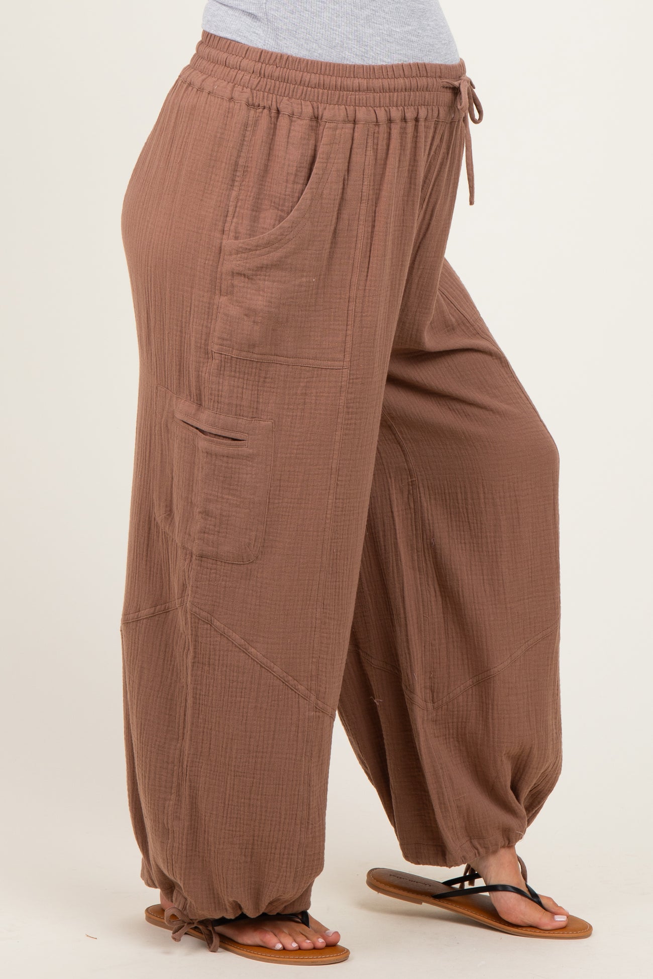 woman wearing soft brown maternity wide-leg pants with pockets and a drawstring waist, showing her baby bump