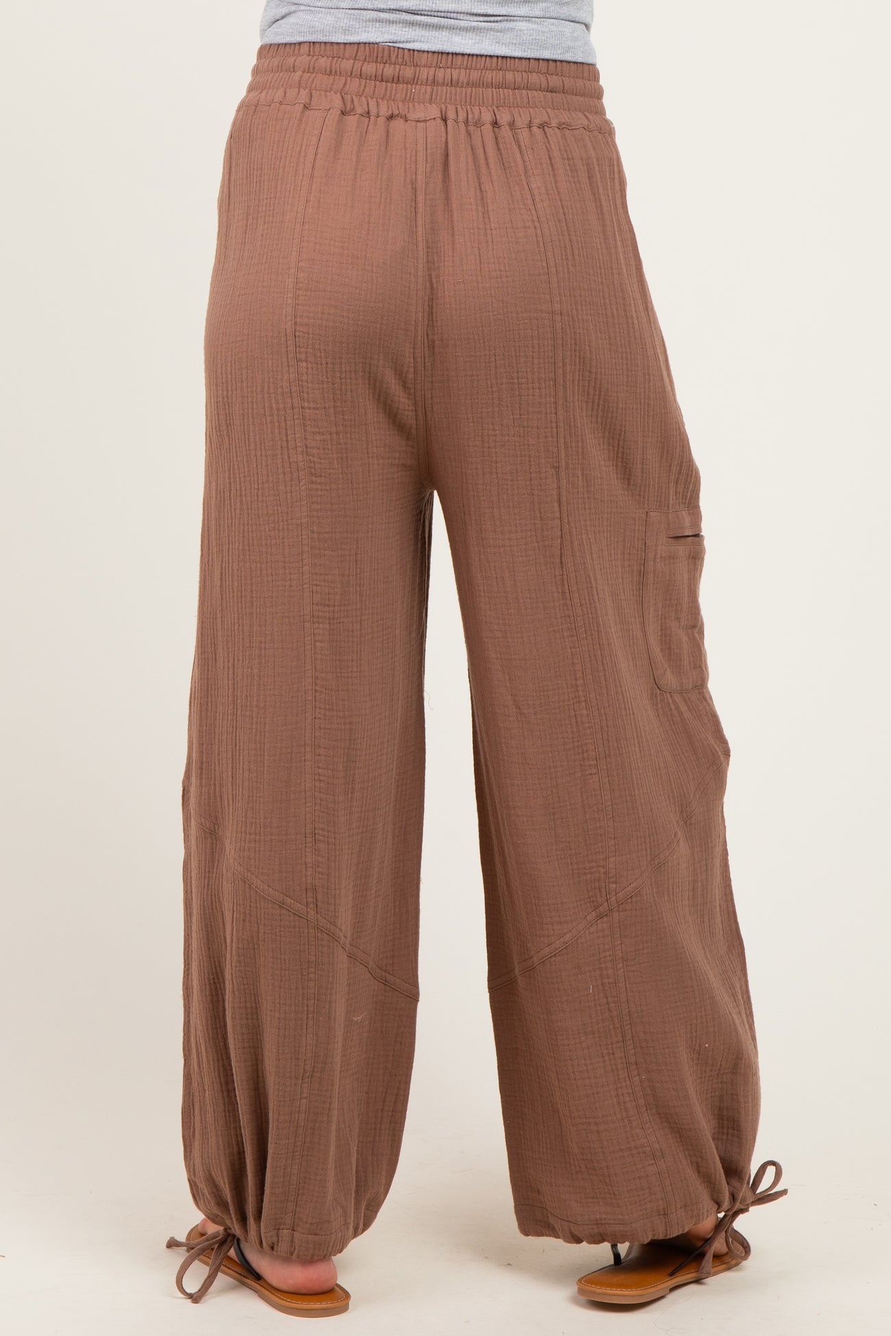 woman wearing brown maternity wide-leg pants with a drawstring hem and side pocket