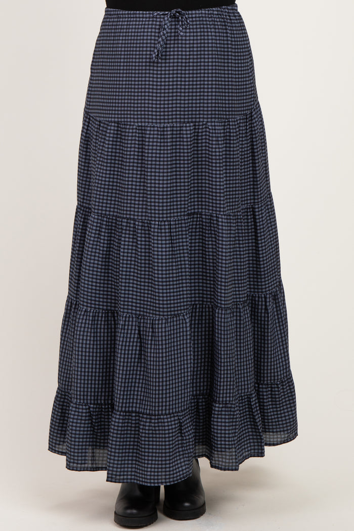 woman wearing a navy and white checked maternity maxi skirt with tiered ruffles and an elastic waistband