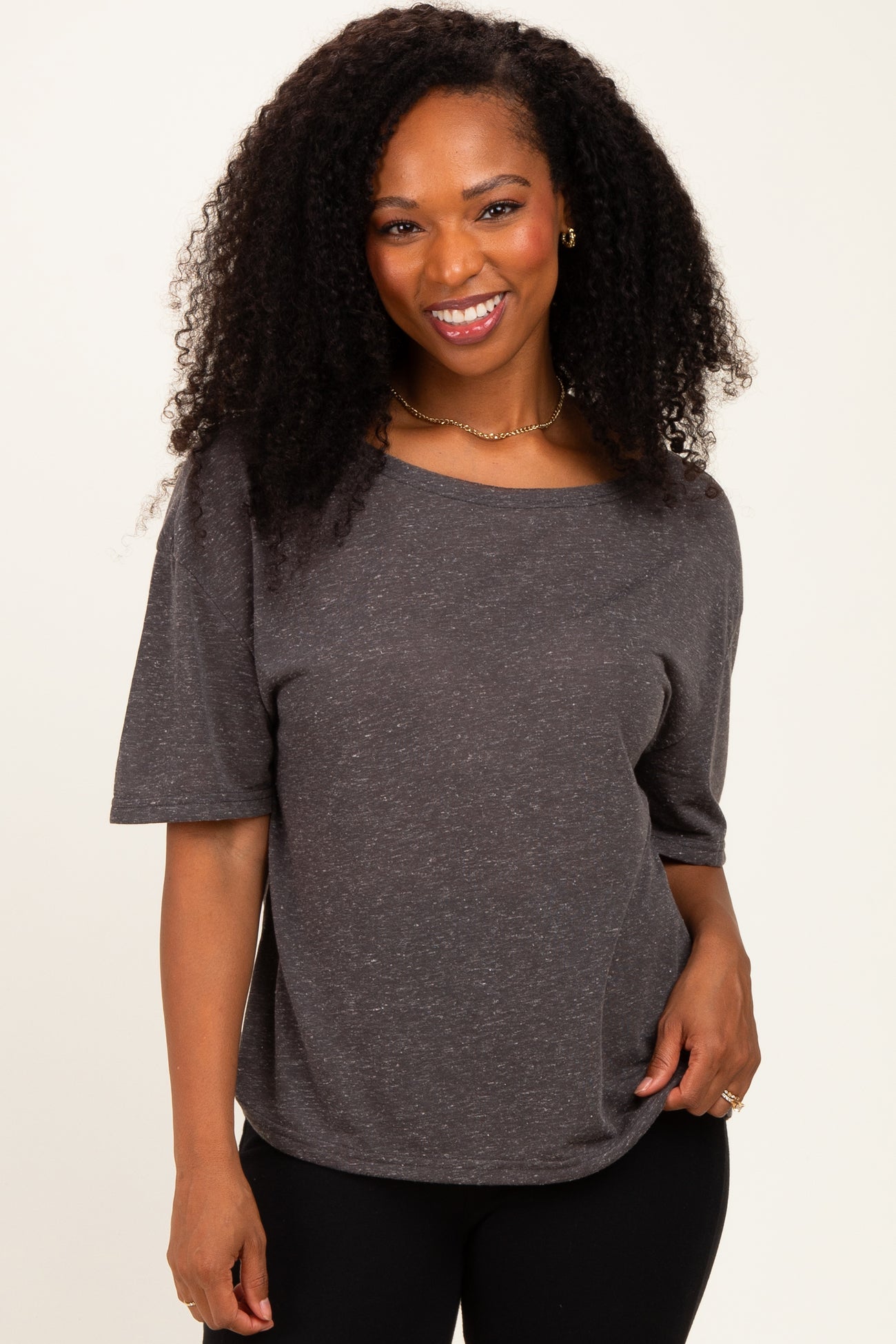 woman wearing a dark gray short sleeve top with a relaxed fit and scoop neckline