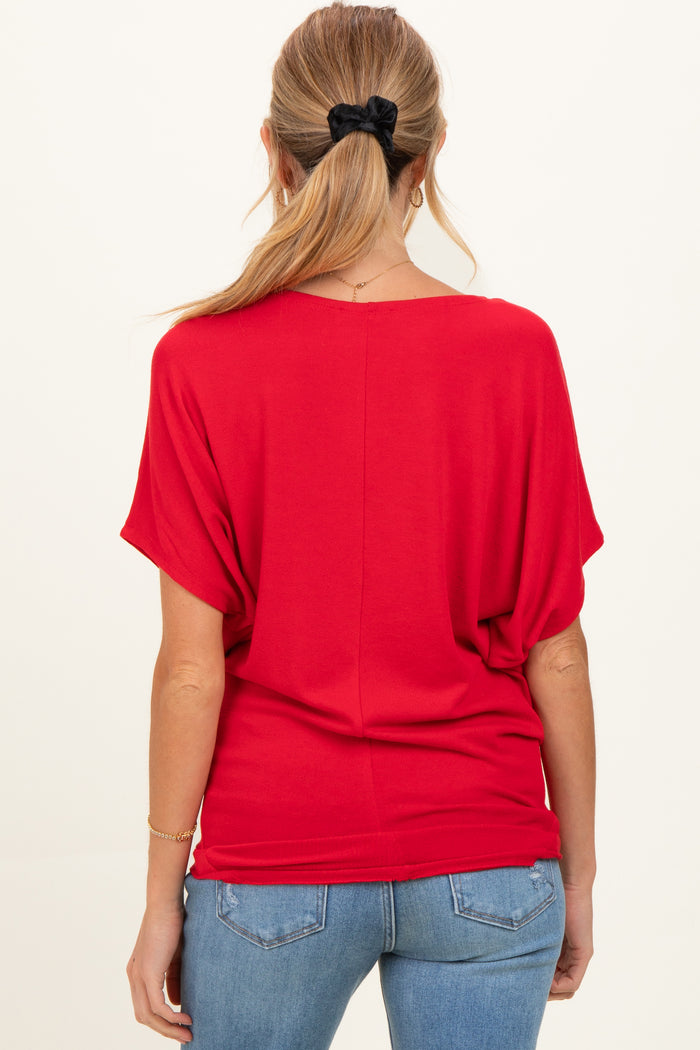 woman wearing a red maternity top with a relaxed fit and batwing sleeves, seen from the back