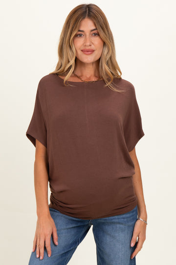 woman wearing a brown maternity top with short sleeves and a relaxed fit, showing her baby bump