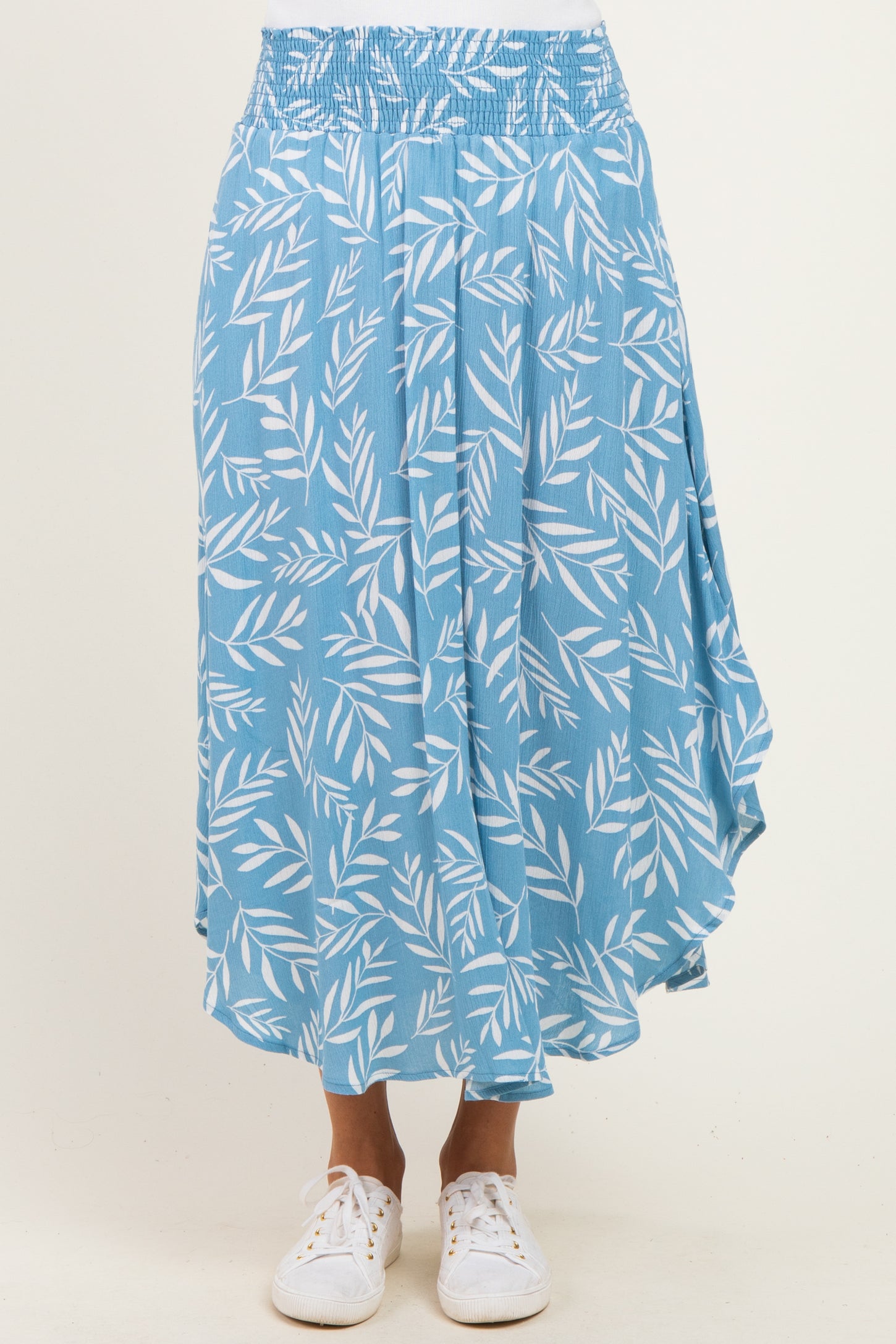 woman wearing a blue patterned midi skirt with a smocked waistband and a flowy hem